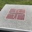 Outdoor game table with Ludo board design.